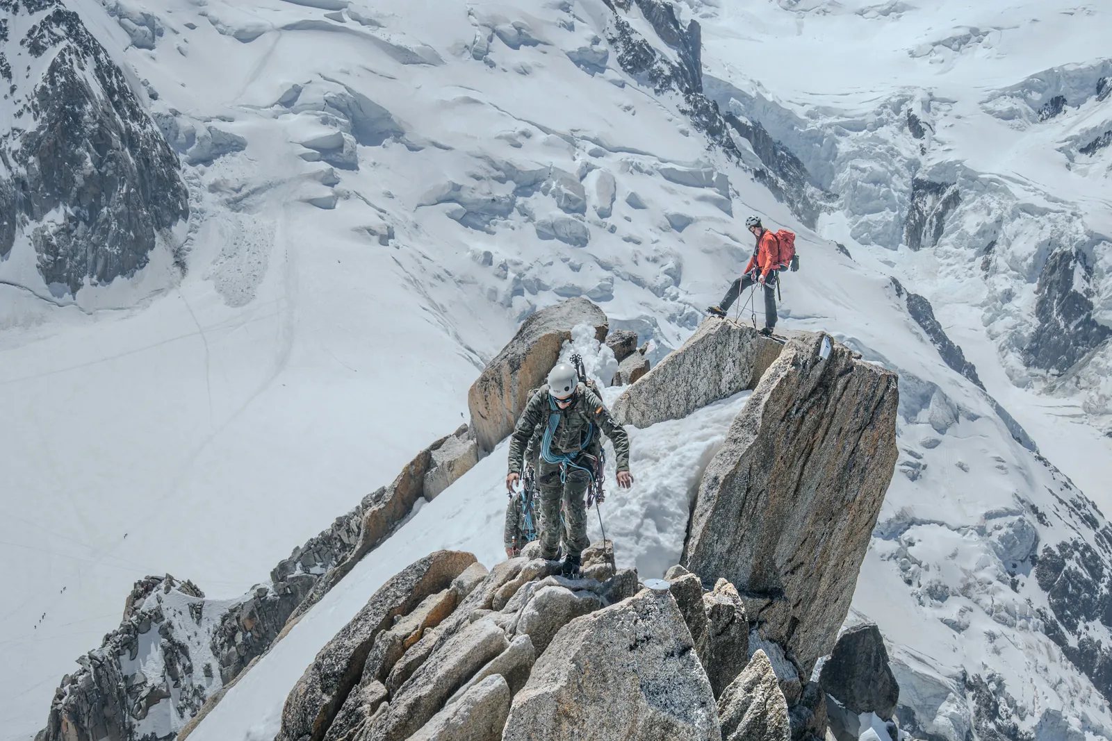 Mountaineers climbing a snowy, rocky summit ridge (Photo: Thibault Lam Tran / Unsplash)