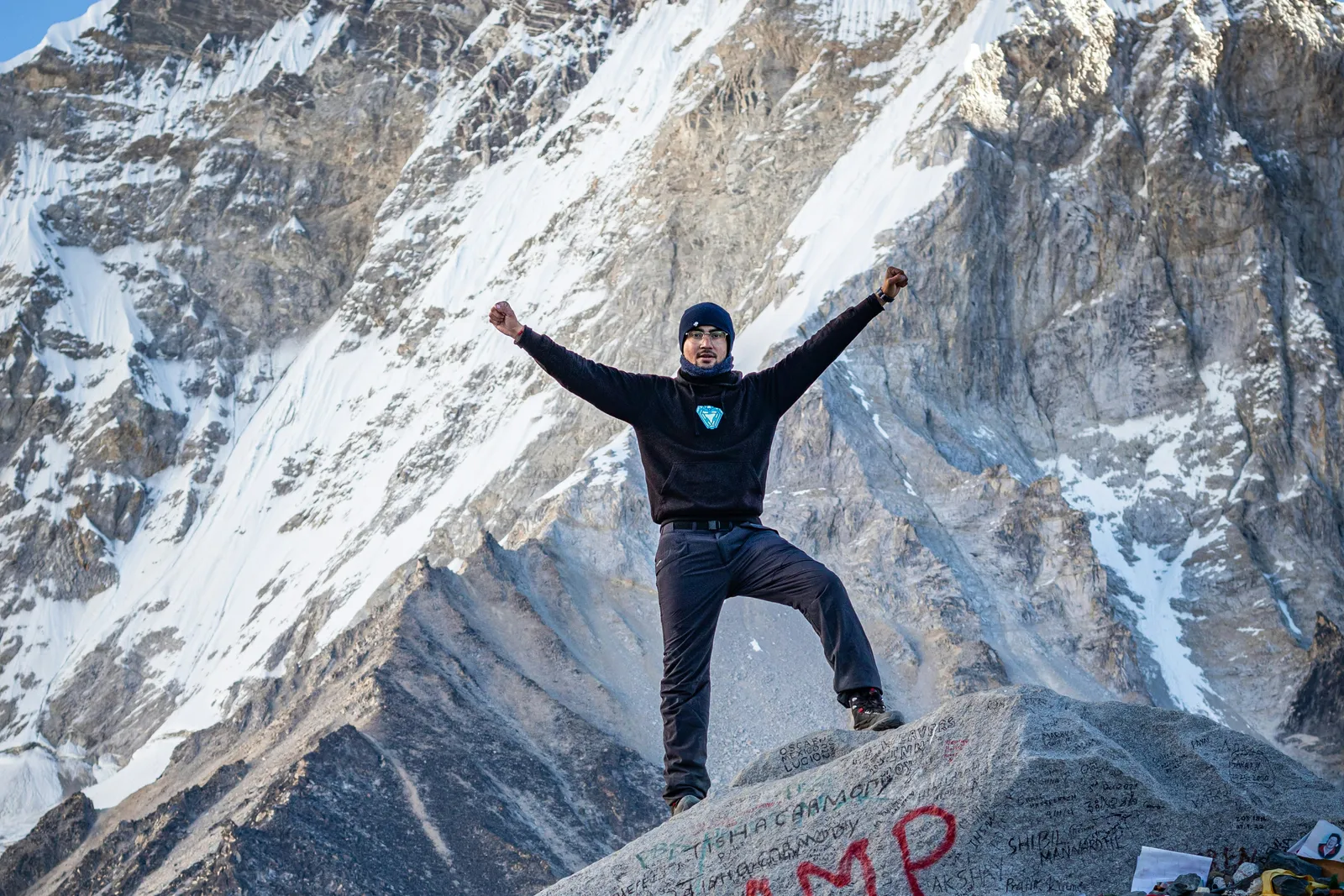 A trekker celebrating on the Everest Base Camp rock (Photo: Pulkit Pithva / Unsplash)